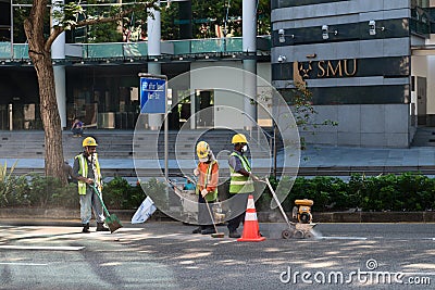 Construction workers repair pavement on a downtown street. Editorial Stock Photo