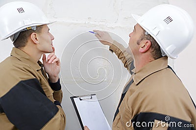 Construction workers talking about wall Stock Photo