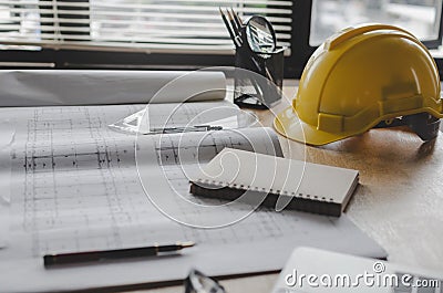 Construction working tool, blueprint and yellow safety helmet on architect workplace desk Stock Photo