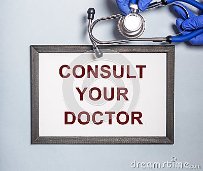 Consult your doctor inscription on paper on table. Medical consultation Stock Photo