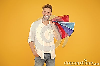 Consumerism concept. Big discount. Great choices great purchases. Happy man holding purchases in paper bags. Cheerful Stock Photo