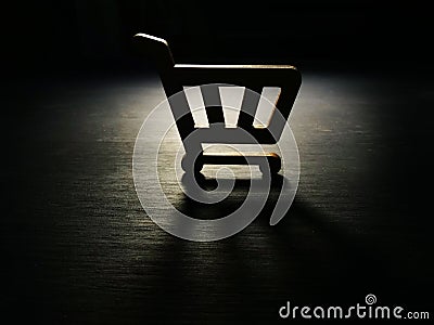 Consumerism. Model of shopping cart in the dark Stock Photo