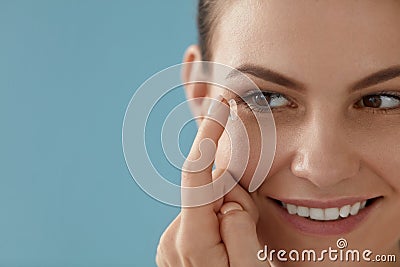 Contact eye lens. Smiling woman applying eye contacts closeup Stock Photo