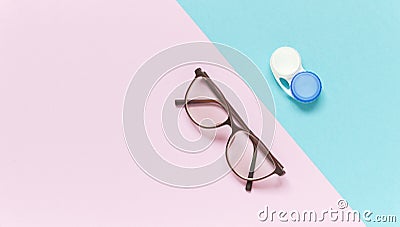 Contact lens case and glasses on blue-purple background. Concept of choice the way vision correction Stock Photo