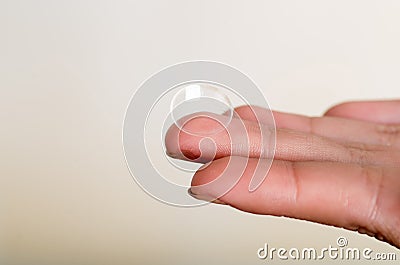 Contact lens on finger on gray background Stock Photo