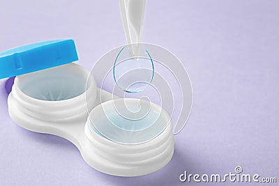 Contact lenses with tweezer and container on pastel purple background Stock Photo