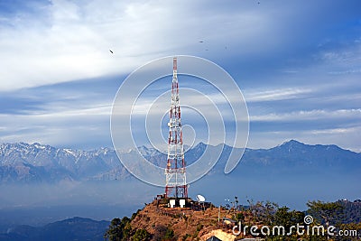 Contact mobile tower at high hilly village of Ashapuri in Himachal Pradesh, India with snow mountains in the backdrop Stock Photo