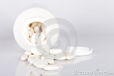 A container of collagen and magnesium pills open on white Stock Photo