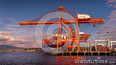 Container Port with the Large Container Cranes loading a Ocean Going Freighter in Vancouver Harbor Editorial Stock Photo