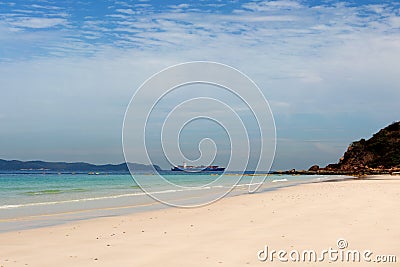 Container shipping by the sea. Sand beach tropical summer background. Cargo ship. Stock Photo