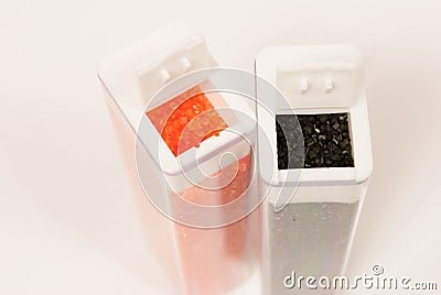 Containers of orange and black sugar Stock Photo