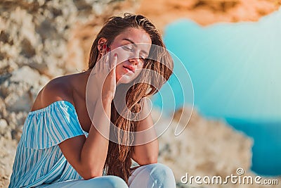 Contemplation and comprehension. Woman sitting on rock and looking away. Relaxing moment and dreaming. Feeling of calm. Stock Photo