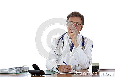 Contemplative aged doctor at desk Stock Photo