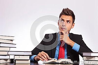 Contemplative man reads at desk Stock Photo