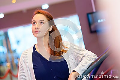 contemplative woman in cinema lobby Stock Photo