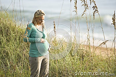 Contemplative young pregnant woman at beach Stock Photo