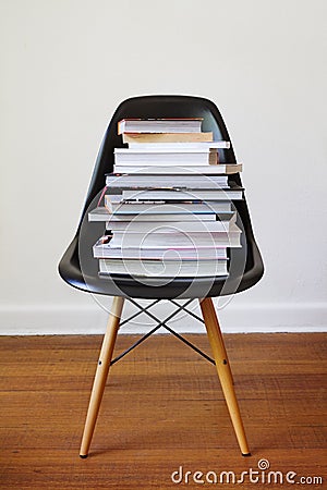 Contemporary black dining chair with stack of books Stock Photo