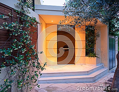 Contemporary design house entrance dark brown door, illuminated Stock Photo