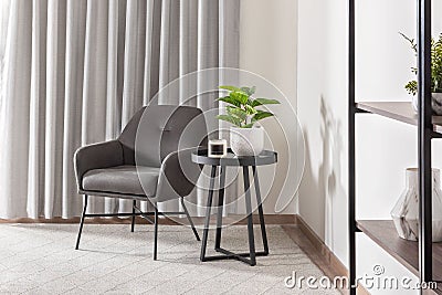 Contemporary grey armchair with a matching table situated in a modern room Stock Photo
