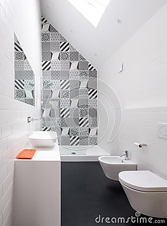 Contemporary loft bathroom with walk in shower unit and black and white monochrome porcelain wall tiles. Stock Photo