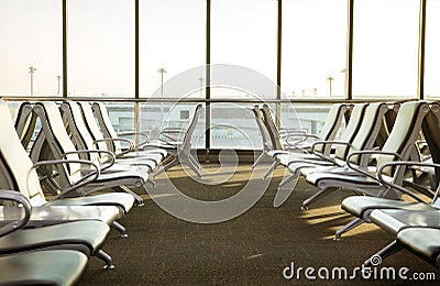 Contemporary lounge with seats in the airport during sun set or Stock Photo