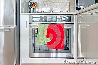 Contemporary, modern chrome stove and oven range, with color screen clock, and green and red dish towels hanging on the oven Stock Photo