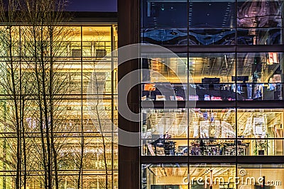 Contemporary office with an illuminated glazed facade at night in the financial district. Modern building typical in tech industry Stock Photo