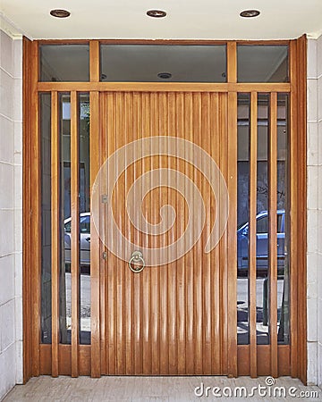 A Contemporary residential building entrance wood and glass door. Stock Photo