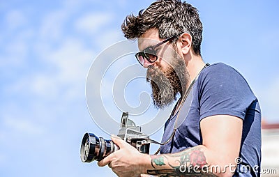 Content creator. Man bearded hipster photographer. Old but still good. Manual settings. Photographer hold vintage camera Stock Photo