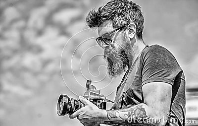 Content creator. Man bearded hipster photographer. Old but still good. Manual settings. Photographer hold vintage camera Stock Photo