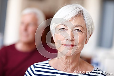 Content in her senior years. Portrait of a senior woman with her husband in the background. Stock Photo