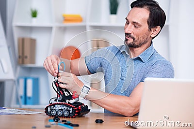 Content man attaching wires to droid Stock Photo