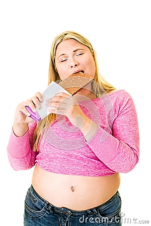 Contented obese woman eating large chocolate bar Stock Photo