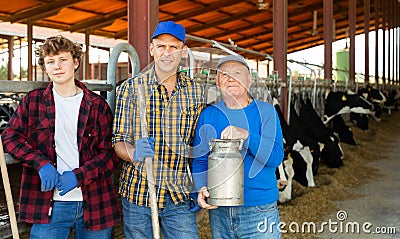 Continuity of generations - portrait of farmers of different ages against the backdrop of cowshed Stock Photo