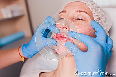 Contour plastic: Lip massage after injection of filler. Stock Photo