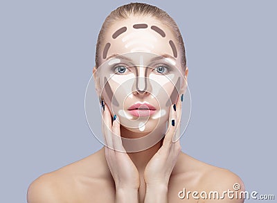 Contouring. Make up woman face on grey background. Contour and highlight makeup. Stock Photo