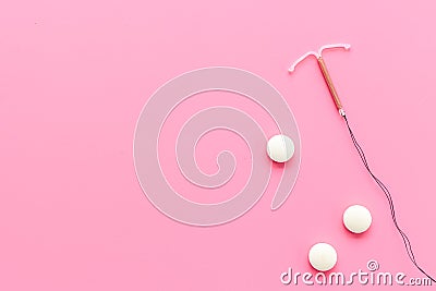 Contraception concept. T-shaped intrauterine contraceptive with medicine pills Stock Photo