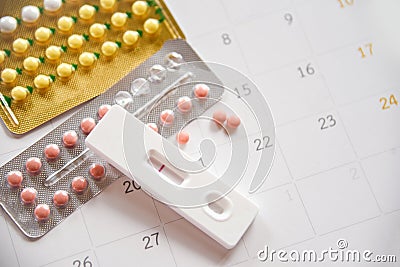 Contraceptive pill and Pregnancy Tests Prevent Pregnancy Contraception concept Birth Control with Condom and roses on calendar Stock Photo