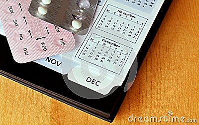 Contraceptive pills with a calendar in the background on a table stock photo Stock Photo
