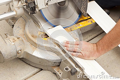 Contractor Cutting New Baseboard for Renovation Stock Photo