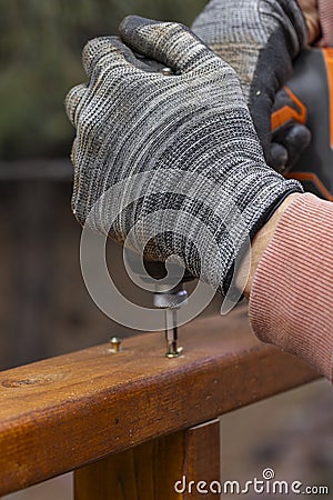 Contractor hanyman using tools to buildi a horizontal fence made from stained cedar Stock Photo