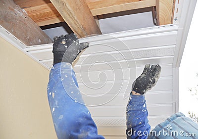 Contractor installing roofing soffit and fascia boards. Stock Photo