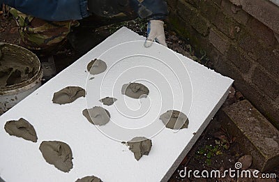 Contractor insulating house wall with styrofoam insulation sheets. Wall insulation with foam board. Stock Photo