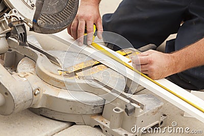 Contractor Measuring for Cutting New Baseboard for Renovation Stock Photo