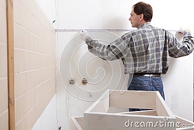 Contractor measuring a kitchen Stock Photo