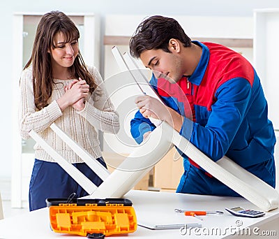 Contractor repairman assembling furniture under woman supervisio Stock Photo