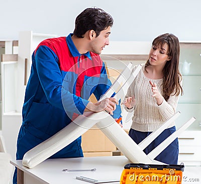 The contractor repairman assembling furniture under woman superv Stock Photo