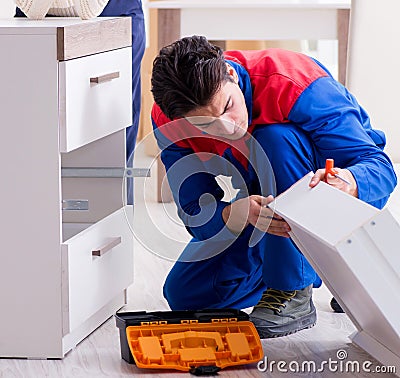 Contractor repairman assembling furniture under woman supervisio Stock Photo