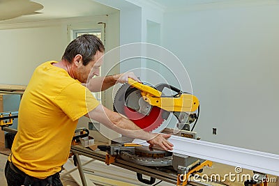 Contractor Using Circular Saw Cutting Crown Moulding for Renovation. Stock Photo