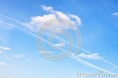 Contrail and fluffy cumuli clouds in blue sky Stock Photo